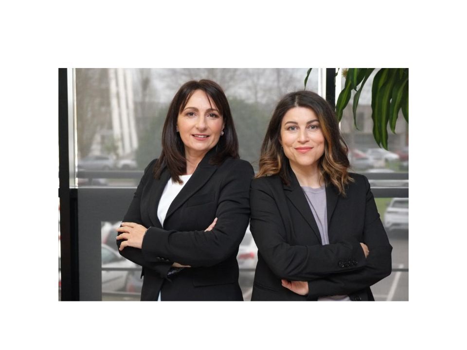 Foto en la que aparece Janet y Marta juntas. Están de brazos cruzados y miran a la cámara.